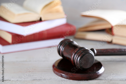 Gavel and books on wooden background