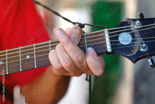 musician playing on an old acoustic guitar