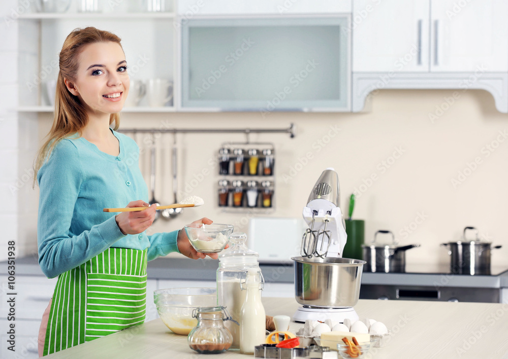 Young woman mixing dough in a bowl Young woman mixing dough in a bowl