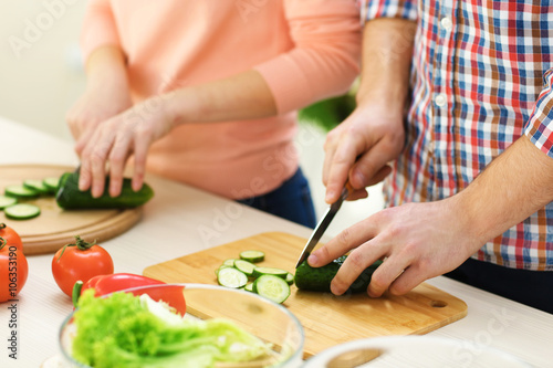 Happy couple cooking salad on the kitchen, close up