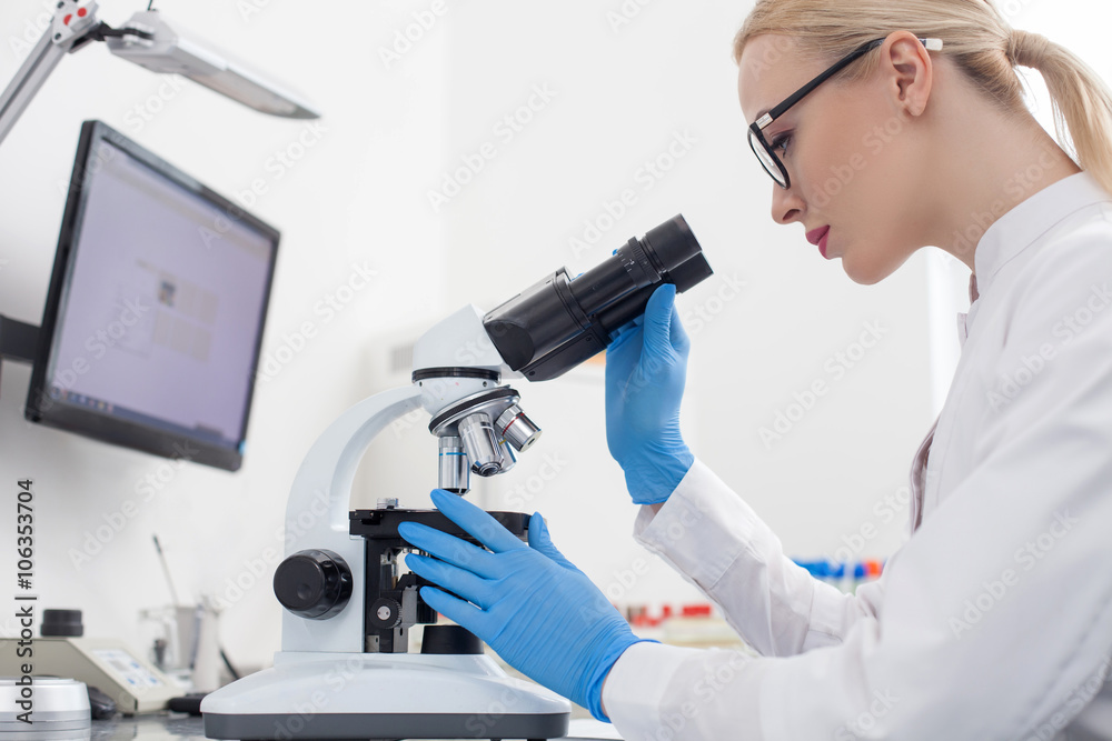 Cheerful young researcher is making the experiments Cheerful young researcher is making the experiments