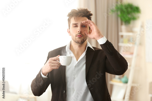 Foto Sleepy guy holding a cup of coffee.