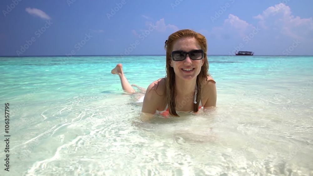 Young slim woman enjoying the turquoise waves of tropical beach. Slow motion. Young slim woman enjoying the turquoise waves of tropical beach. Slow motion.