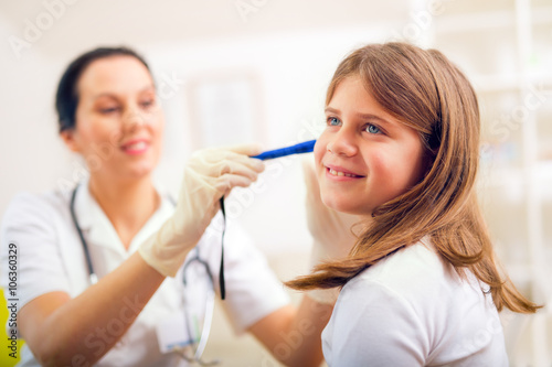 Female doctor examining little girl. Horizontal view of girl dur