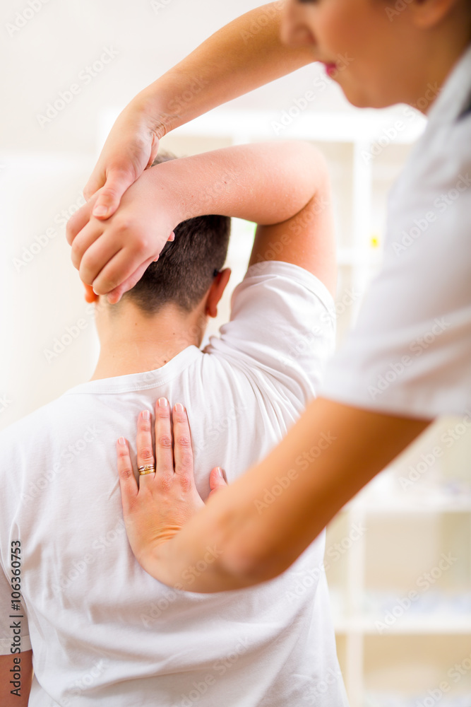 Chiropractor doing adjustment on male patient. Selective focus Chiropractor doing adjustment on male patient. Selective focus