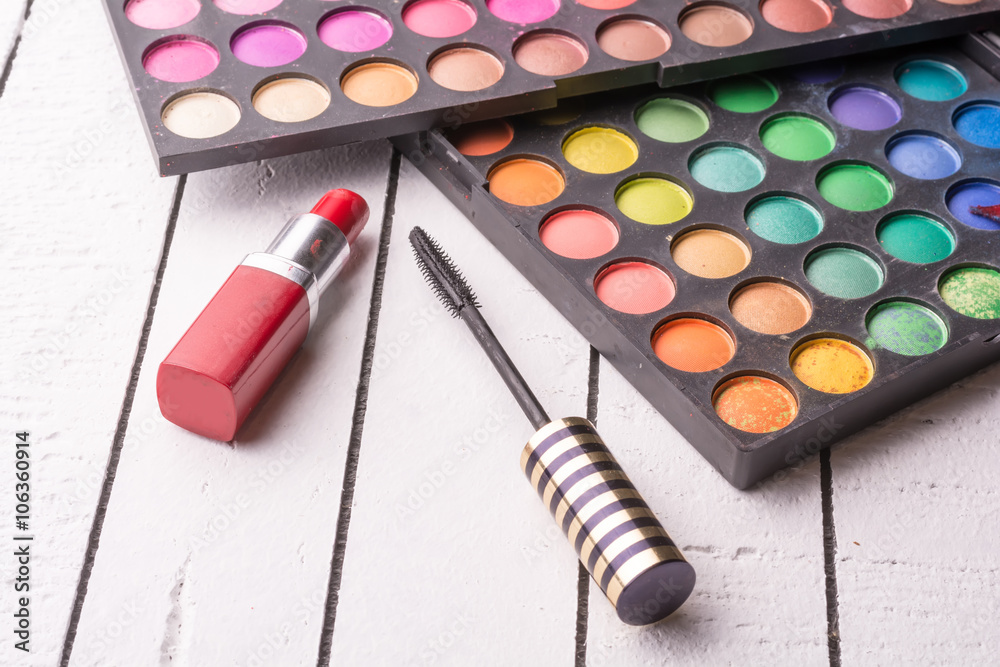 Eye shadow, red lipstick and mascara on a white wooden background Eye shadow, red lipstick and mascara on a white wooden background
