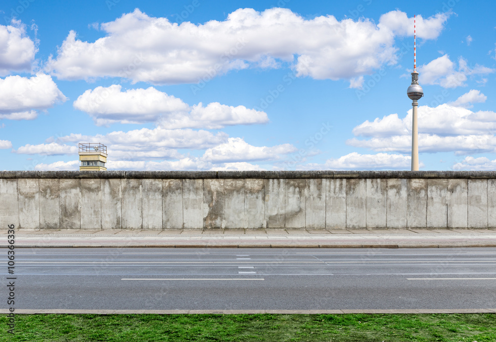 Obraz premium Mur berliński z wieżą obserwacyjną i wieżą telewizyjną