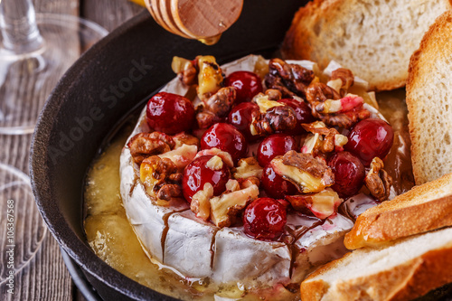 Homemade baked brie with honey, cranberry and walnut.