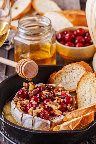 Homemade baked brie with honey, cranberry and walnut.