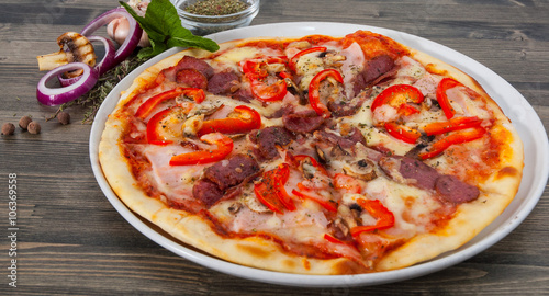 Appetizing pizza with mushrooms, salami, vegetables