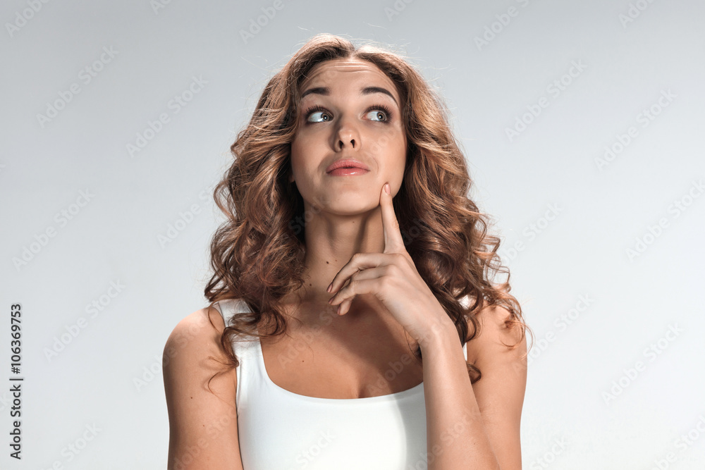 The happy thoughtful woman on gray background The happy thoughtful woman on gray background