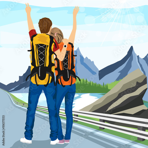 young couple of hitchhikers standing on road and enjoying mountain scenery 