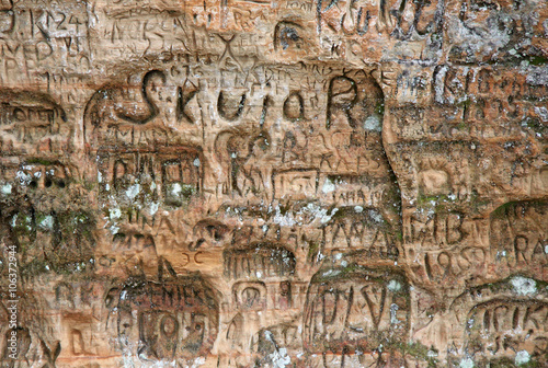 SIGULDA, LATVIA - MARCH 17, 2012: Old inscriptions in the Gautmanis Cave located on the Gauja River in the National Park of Sigulda, Latvia
