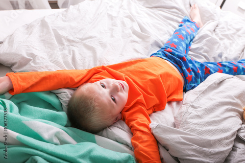 Ein kleiner Junge in Pyjama hüpft auf dem Bett