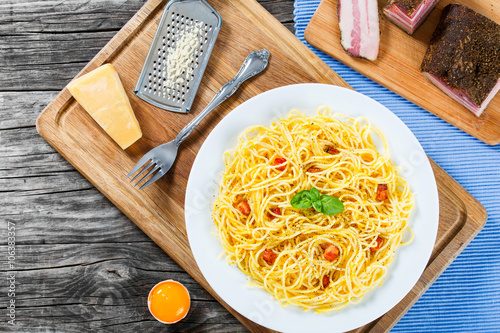 Spaghetti carbonara, basil, eggs yolk, grated parmesan cheese, b