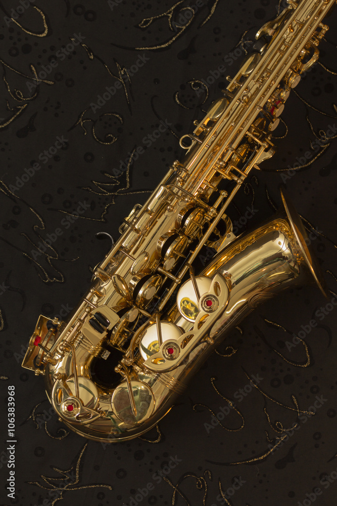 Fototapeta premium Golden saxophone and music sheets on a black background