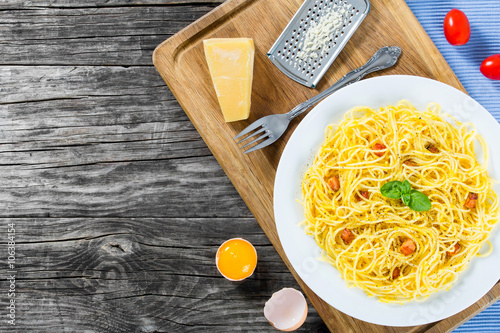 Spaghetti carbonara, basil, eggs yolk, grated parmesan cheese