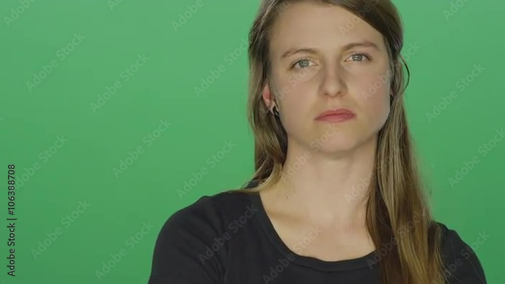 Young women looks upset and shakes her head, on a green screen studio background Young women looks upset and shakes her head, on a green screen studio background