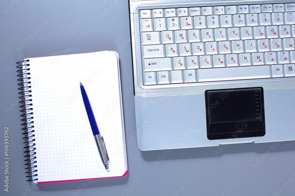Office table with blank notepad and laptop Office table with blank notepad and laptop