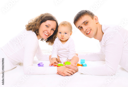 Happy family together parents and baby playing with toys on floo