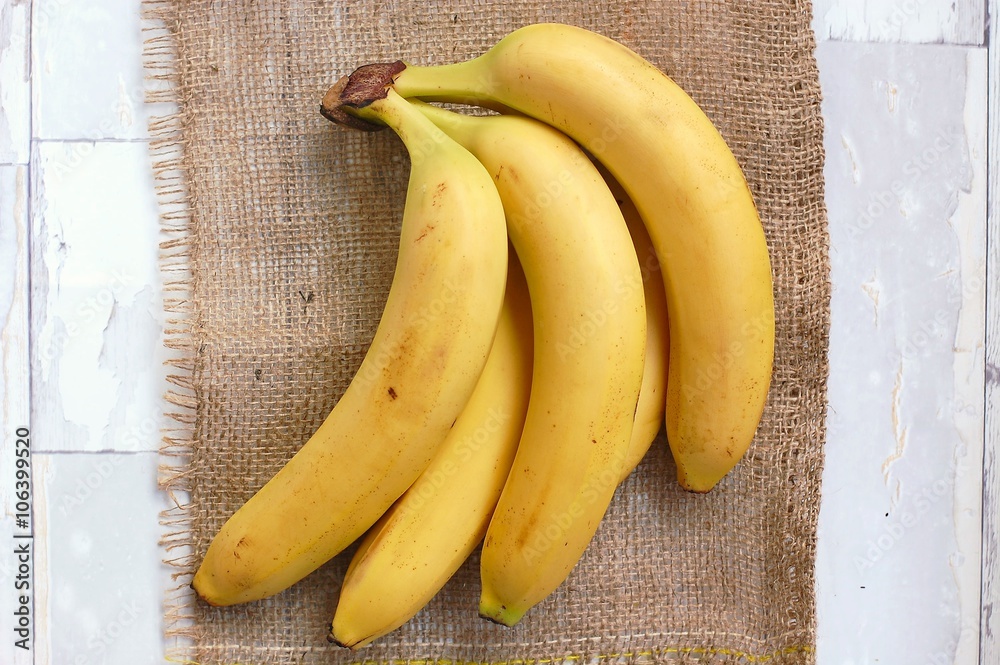 Bananas on the gunny cloth and wooden background Bananas on the gunny cloth and wooden background