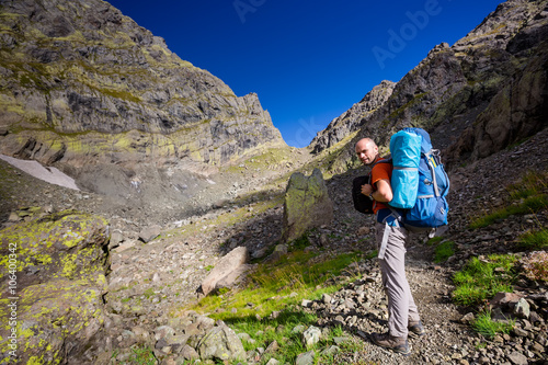 Man with backpack hiking in Caucasus mountains in Georgia