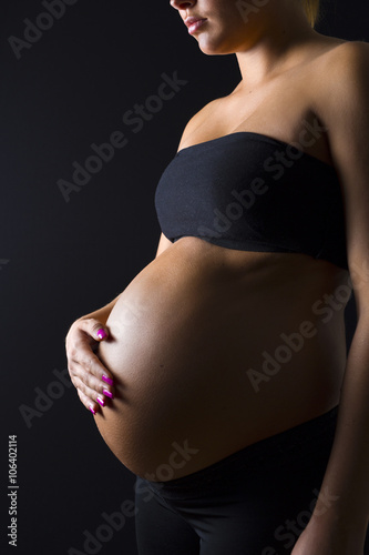 Pregnant woman with her hand on the bare belly