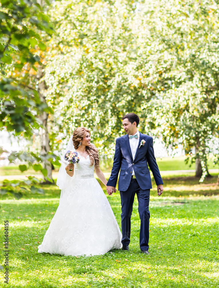 Wedding couple holding hands outdoors Wedding couple holding hands outdoors