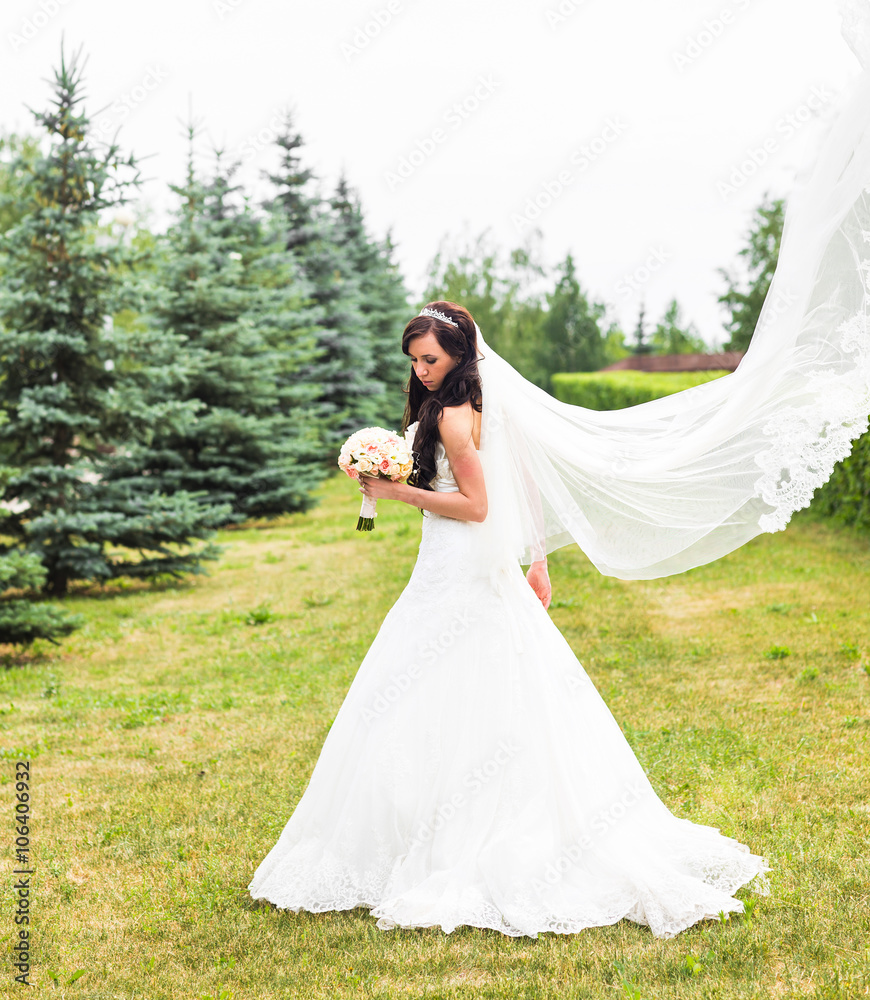 Beautiful bride with bouquet of flowers outdoor