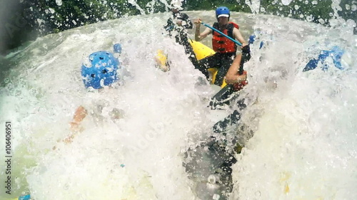 A group of adventurers in a yellow raft navigate fast-moving rapids near Banos, Ecuador, paddling in unison through churning whitewater in a dynamic low-angle onboard shot.