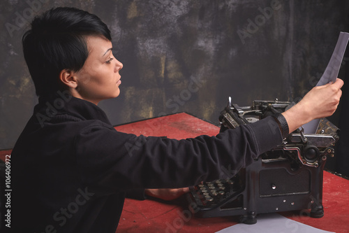 Fotografía Young woman writer in creative process, retro typewriter, art space