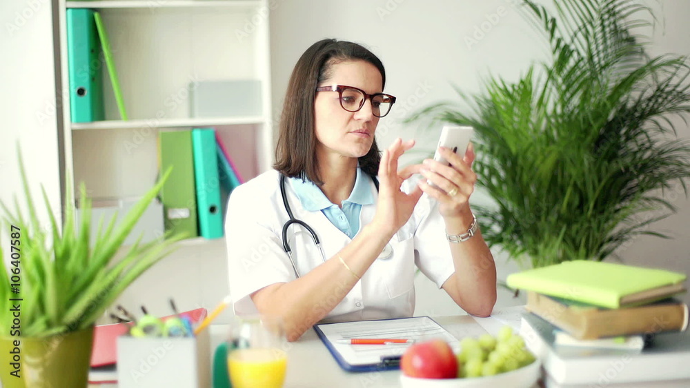 Doctor sitting in the office and typing message on smartphone
Doctor sitting in the office and typing message on smartphone