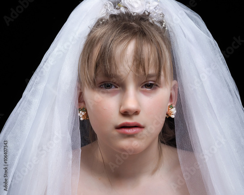 Teen girl - the bride. Portrait of a young, weeping bride. The concept of early marriages with underage children