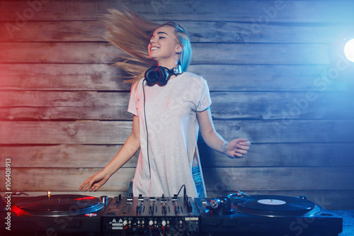 Obraz na plátně Cute dj woman having fun playing music at club party