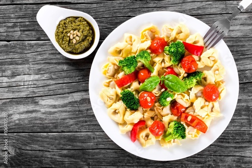 Tortellini with grilled cherry tomatoes, broccoli, red bell pepper, top view
