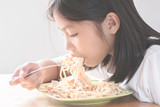 Asian child eating spaghetti
