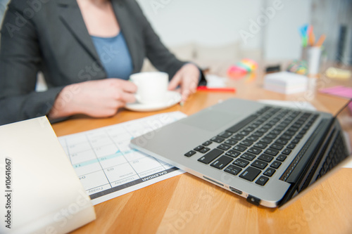 Successful businesswoman is enjoying drink in office