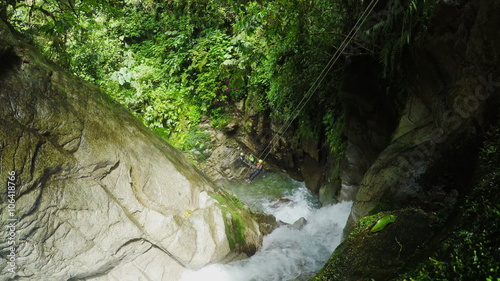 Experience the thrill of ziplining over a breathtaking waterfall in Llanganates National Park during an exhilarating canyoning expedition,captured on a static camera with immersive sound.