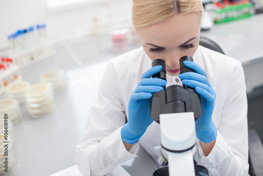 Cheerful female scientist is making tests in lab Cheerful female scientist is making tests in lab