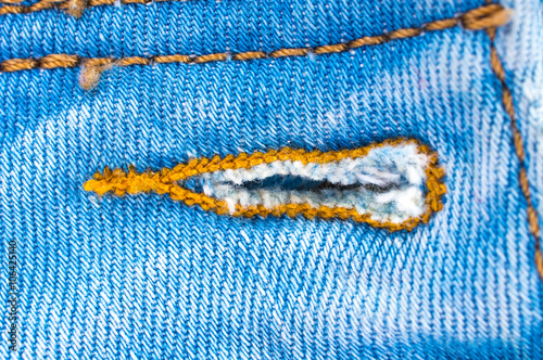 Blue jeans fabric texture close up, trims, seams, pockets.