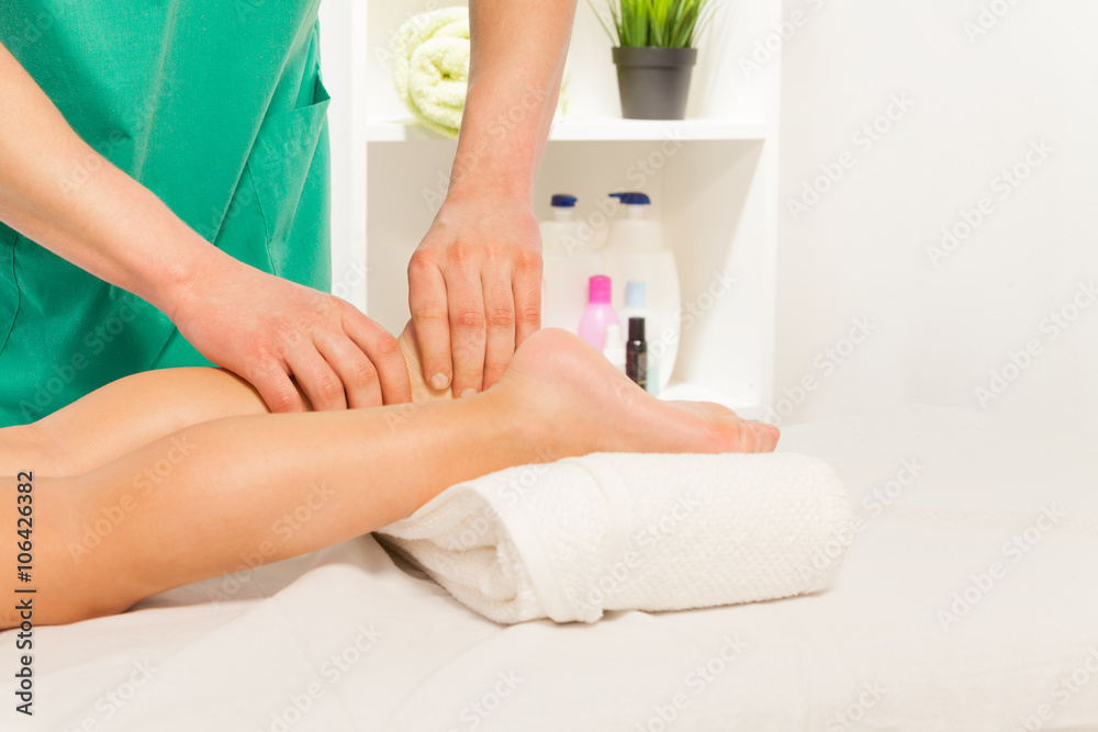 Fototapeta premium Massage therapist massaging boy foot at cabinet