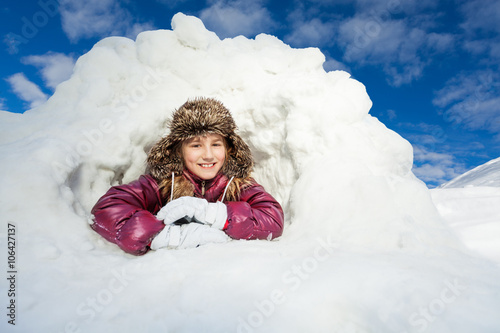 Girl having fun in snow cave at winter day