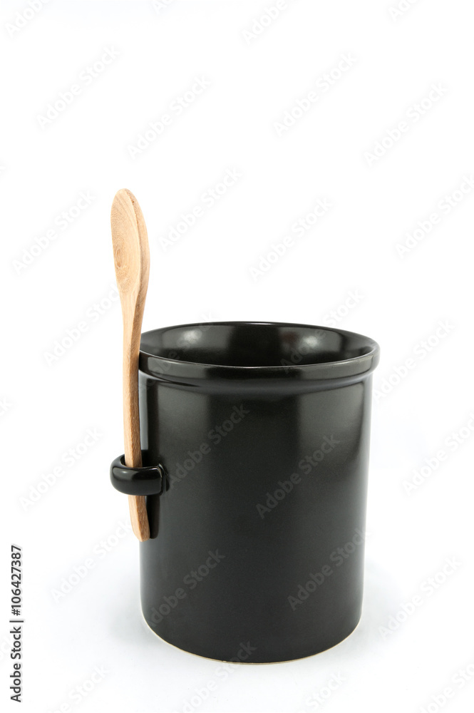 Black cup with wooden spoon isolated on white background. Black cup with wooden spoon isolated on white background.