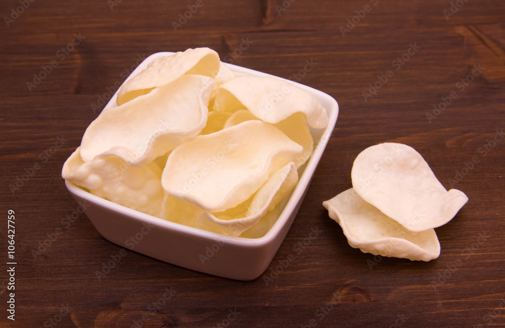 Krupuk on a square bowl on wooden table Krupuk on a square bowl on wooden table