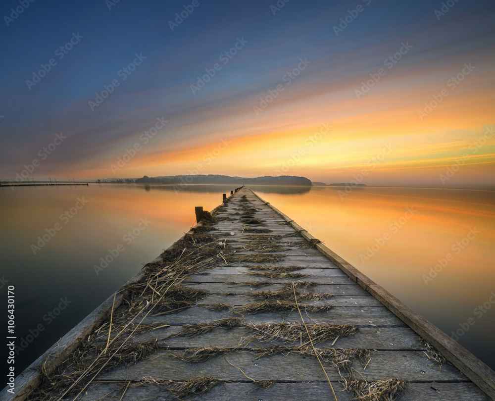 wooden, white pier on the bay at sunset