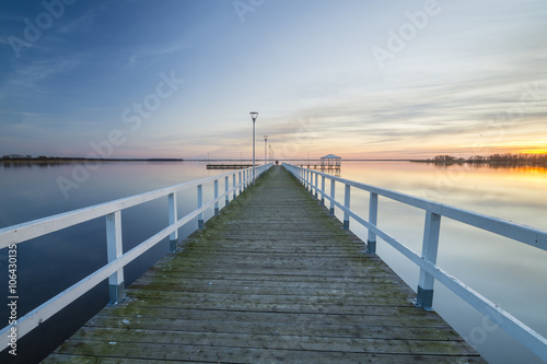 wooden, white pier on the bay at sunset