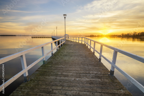 wooden  white pier on the bay at sunset