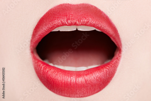 Closeup view of female wearing red lipstick with mouth open