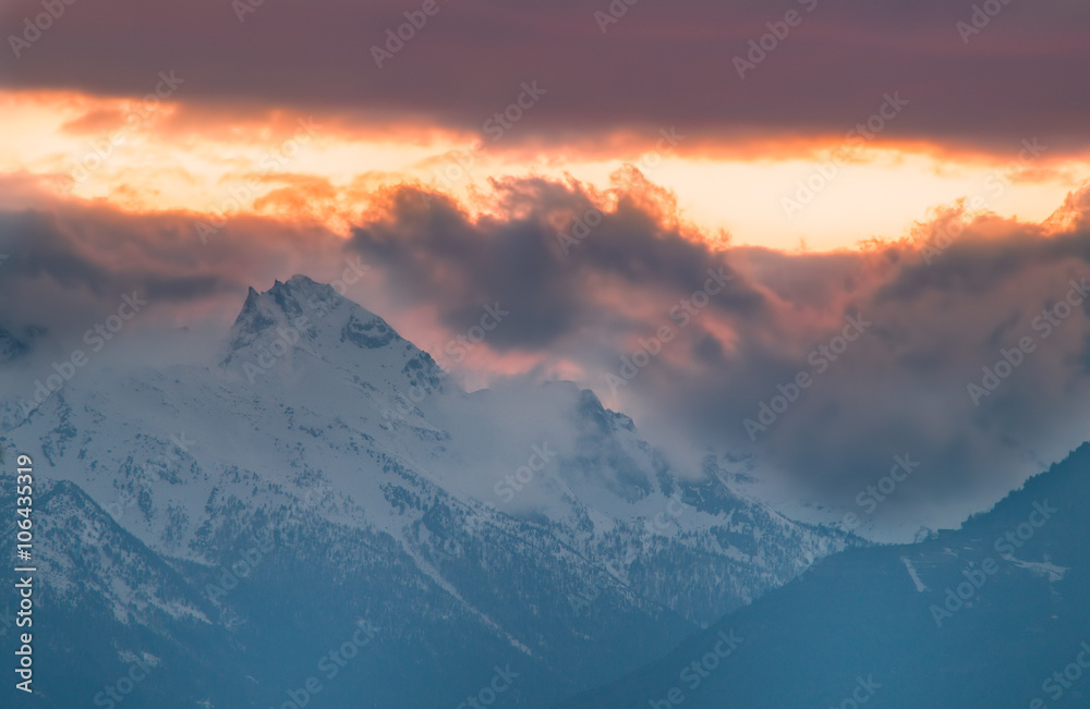 Panorama montano, montagne innevate tramonto, tramonto montano con cielo rosso e giallo