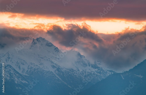 Panorama montano, montagne innevate tramonto, tramonto montano con cielo rosso e giallo © mashiro2004